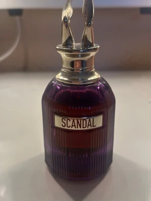 Scandal parfym Intense från Jean Paul Gaultier - En lyxig parfymflaska från Jean Paul Gaultier med namnet Scandal. Flaskan är djupt lila med guldfärgat lock format som ett par ben. Perfekt för dig som vill sticka ut med din doft. 50 ml provad vid några tillfällen men nästan full 