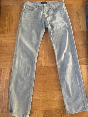 Gråa jeans från J.Lindeberg - Säljer ett par sällsyntare gråa straight leg jeans från J.Lindeberg med klassisk femficksdesign i storlek 31/32. Jeansen har snygg diskret JL-logo på myntfickan. Inga defekter