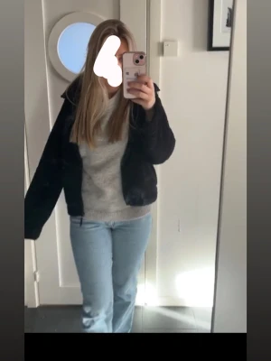 Svart teddyjacka i storlek S - Mysig svart teddyjacka med krage och dragkedja. Jackan har en fluffig textur och avslappnad passform, perfekt för att hålla värmen under kyliga dagar. Passar till många olika stilar och är enkel att matcha med jeans eller kjol.