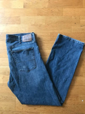 Blå raka jeans från Denizen Levi's - Klassiska blå jeans från Denizen Levi's med rak passform och femficksmodell. Jeansen har en snygg mellanblå tvätt och detaljer som synliga sömmar och läderpatch bak i midjan. Perfekta till en avslappnad stil.