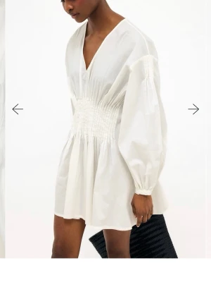 Vit kort klänning med v-ringning nakd - Oanvänd, hann inte skicka tillbaka. Jättefin men för stor för mig. Super fin att ha som studentklänning!