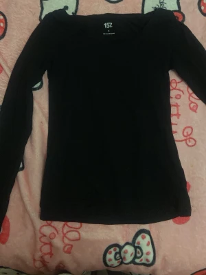 Svart långärmad topp från 157 - En enkel och stilren svart långärmad topp från 157. Tillverkad i mjuk bomull som känns skön mot huden. Perfekt basplagg med normal passform och rund halsringning. Lätt att matcha med allt i garderoben.