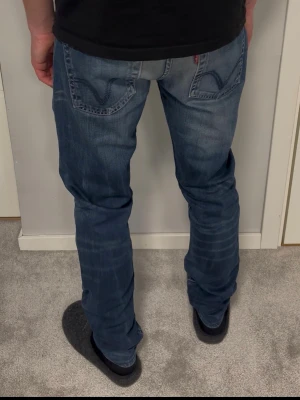 Levis 506 Standard - Levis 506 Standard. Blåa med schyssta fades. Bra skick, *minimalt hål och väldigt svaga fläckar på höger knä (se bild 5). Size 33/32. Modellen på bilderna är 183cm och väger 67kg. Mått, Ytterbenslängd: 106cm. Midja: 42cm. Lårbredd: 29cm. Benöppning: 18cm. Hör av dig vid funderingar!