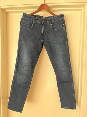 Mörkblå slim fit jeans från Replay - Snygga mörkblå jeans från Replay med klassisk femficksdesig. Jeansen har normal midja, dragkedja med knapp och Replay-logga på fickan. Perfekta för en trendig och avslappnad stil. Använd fåtal gånger🤩hör av er vid minsta lilla fundering😇 pris kan diskuteras vid ett snabb köp🤗