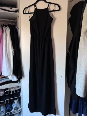 Svart långklänning från Bik Bok, stl XS - Svart långklänning från Bik Bok med smala axelband och enkel, stilren design. Rak passform och minimalistisk stil!
