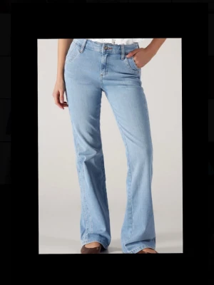 Ljusblå bootcut jeans - Säljer ett par ljusblå bootcut jeans med klassisk femficksdesign och normal midja. Jeansen har utsvängda ben och är tillverkade i denim med en snygg tvätt. Perfekta för dig som gillar retrovibbar och avslappnad stil.