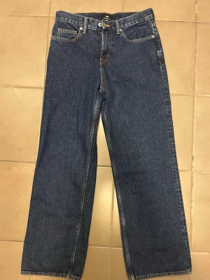 Mörkblå raka jeans - Säljer ett par mörkblå H&M Straight Relaxed Fit jeans i storlek 30/32. Använda endast 1 gång så de är i väldigt fint skick, nästan som nya. Bekväm och snygg passform som funkar till det mesta.
