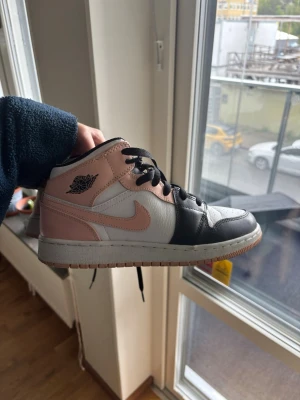 Air Jordan 1 Mid  - Snygga Air Jordan 1 Mid sneakers i rosa, svart och vitt läder. Perfekta för dig som vill sticka ut med stilrena och trendiga sneakers😍