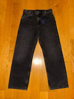 Svarta raka jeans från GANT - Snygga svarta jeans från GANT med rak passform. Jeansen har hög midja och är tillverkade i ett mjukt denimtyg. Helt oanvända, etiketter finns kvar! Strl 170