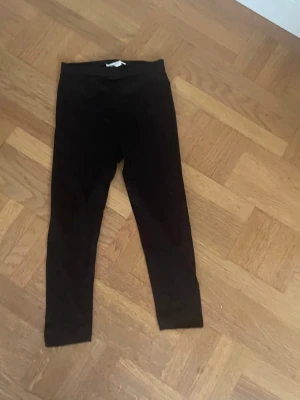 Svarta leggings med hög midja - Ett par klassiska svarta leggings med hög midja och smal passform. Perfekta att matcha med oversized tröjor eller hoodies. Mjukt och stretchigt material som sitter skönt hela dagen.