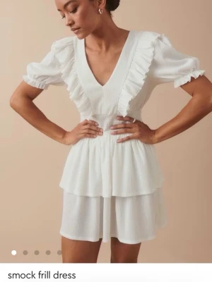 Vit smockad volangklänning XS - Supersöt vit klänning från Gina tricot💕 Aldrig andvänd och lapp finns kvar!! Säljs ej längre på Gina! Passar perfekt till studenten, middag eller liknande🥂💗