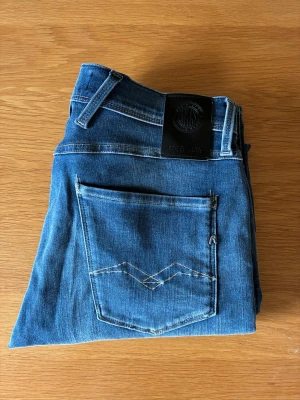 Blå jeans från replay Jeans - Snygga blå jeans från replay Jeans med klassisk femficksdesign och kontrastsömmar på bakfickan. Jeansen har en rak passform och är tillverkade i mjukt denimtyg. Perfekta för en avslappnad och stilren look.