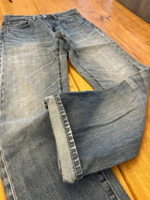 Levi’s 505 Regular Fit Jeans (W29 L33) 🇯🇵 - Levi’s 505 Regular Fit Jeans (W29 L33) 🇯🇵 Vintage light wash with soft dusty blue tones, whiskering & natural vertical fading • Classic straight-leg fit, relaxed top block • Zip fly, arcuate stitching & red tab • Worn paper patch adds character • Subtle abrasion & authentic wear throughout Soft, broken-in denim with great everyday appeal  Feel free to ask for more details! (7)