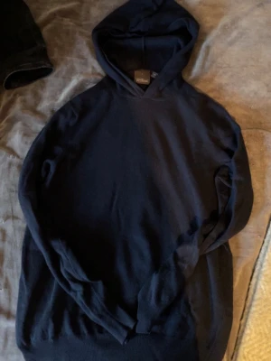 Mörkblå hoodie från Oscar Jacobson - Snygg mörkblå hoodie från Oscar Jacobson, tillverkad i cashmere. Hoodien har en klassisk huva och är gjord i ett mjukt material som känns lyxigt. Perfekt för dig som gillar stilrena och enkla plagg med premiumkänsla.