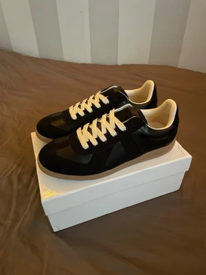 Maison Margiela svarta sneakers - Hej😇 säljer nu ett par riktig fina maison margiellas i storlek 42 som passar bra nu till sommaren!🤗 Skriv om ni har några frågor eller annat.
