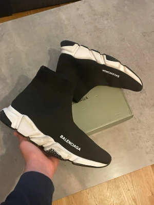 Trainer svarta sneakers - Svarta  Speed Trainer sneakers med vit chunky sula och stickad ovandel i stretchigt tyg. Strumpmodell med logga på sidan och modern, sportig vibe. Perfekta för dig som gillar streetwear och vill sticka ut med en ikonisk design.