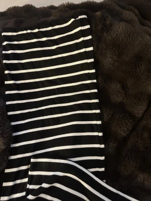 Svartvit randig ribbad kjol - Snygg svartvit randig kjol med ribbad struktur. Kjolen har raka linjer och är stretchig, perfekt för en trendig look. Passar dig som gillar enkel men stilren design. kan användas som en tub klänning