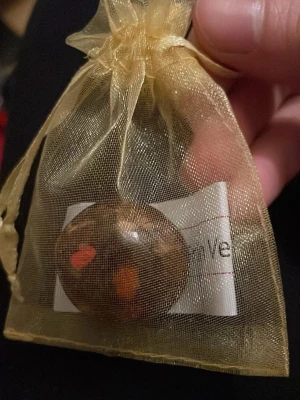Marmorerad sten i guldpåse- kula - En rund marmorerad sten med bruna, orange och röda inslag, levereras i en skimrande guldnätspåse med dragsko. Perfekt som dekoration, lyckosten eller present. Påsen är genomskinlig och ger ett lyxigt intryck.
