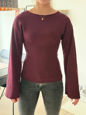 Vinröd långärmad topp från Nelly - Snygg vinröd topp från Nelly med lång ärm och figursyd passform. Toppen har ett mjukt material som känns skönt mot huden. Enkel och stilren design utan mönster eller detaljer. Toppen matchar till allt✨😍