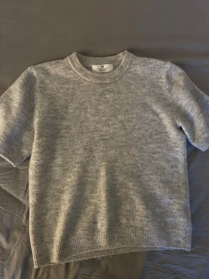 Ljusgrå stickad tröja från H&M - Mysig ljusgrå stickad tröja från H&M med korta ärmar och rund halsringning. Jätte skön och den sticker inte alls 💕