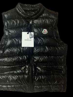 Moncler Gui Väst  - Moncler Gui Väst i storlek 1 som motsvarar storlek S, västen har Tagsen. Och västen har NFC 