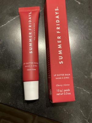 Summer Fridays Lip Butter Balm Cherry - Cherry Lip Butter Balm från Summer Fridays i en snygg röd tub med vit kork. Innehåller 15 g och är vegansk. Ger läpparna en mjuk och återfuktad känsla med en hint av körsbär. Perfekt att ha i väskan för daglig användning.