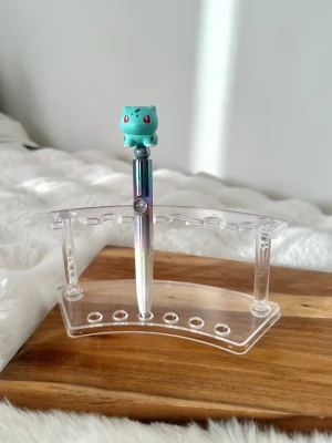 Pokémon Bulbasaur bläckpenna - Säljer en färgglad bläckpenna med en Bulbasaur-figur på toppen.  Varje klick på pennan så ändras djuret i det lilla runda fönstret 
