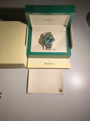 Herr klocka - Full set - Submariner “Hulk” 40mm Säljer en oanvänd Submariner med grön urtavla och grön keramisk bezel – en av mest ikoniska och eftertraktade modeller. Klockan är i nyskick och aldrig använd. • Modell: Submariner Date • Storlek: 40mm • Urverk: Automatisk • Funktion: Datum • Oyster-länk i stål • Grön keramisk bezel & grön sunburst-tavla  1500kr utan box och certifikat