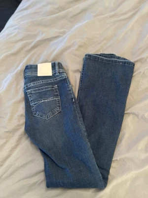 Lågmidjade jeans från bik bok  - Snygga blå bootcut jeans med lågmidjade från bik bok. Dom är uppsprättade längst ner. Men annars är dom som nya då dom knappt är använda. 