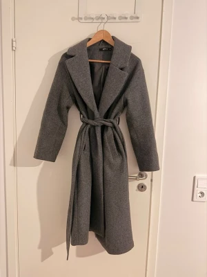 Grå kappa från Gina Tricot - Storlek XS (passar även S & M) - Säljer min gråa kappa från Gina Tricot, storlek XS i använt skick. Kappan har blivit nopprig över tiden men inget lite tid och en rakhyvel inte kan fixa 🪒 jackan är annars i jättebra skick och har inga andra skavanker 😊