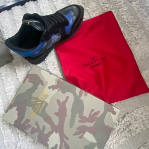 Valentino Rockrunner - Säljer ett par sköna Valentino Rockrunner med blått och svart camo-mönster. Kommer med originalkartong och röd dustbag. Perfekta för dig som vill sticka ut med exklusiva sneakers. Skick = 7.5/10   Storlek 42 men passar bra som 41