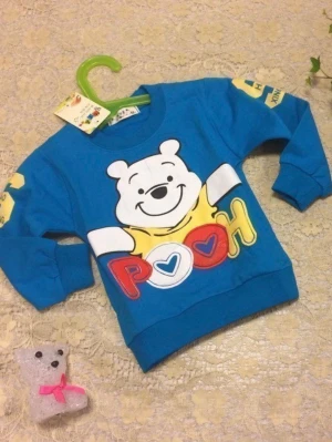 Blå tröja med Nalle Puh-tryck - Blå långärmad tröja med stort färgglatt Nalle Puh-tryck framtill. Tröjan har ribbade muddar vid ärmslut och nederkant samt rund halsringning. Perfekt för dig som gillar söta och lekfulla motiv.