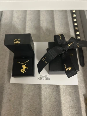Maria Nilsdotter halsband  - Säljer ett guldpläterad halsband på 925 silver från Maria Nilsdotter, kedjan är 45cm, i otroligt bra skick då de inköptes för ungefär ett år sedan men inte blivit använt på ett halvår❣️ Från deras ”stötta barncancer” kollektion. halsband, ask och maria nilsdotter kort ingår (allt på första bilden)  Nypris var då 2700kr🥰  