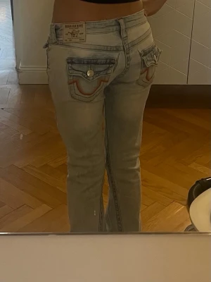 Lågmidjade true religion jeans - Snygga lågmidjade flare jeans från True Religion med coola fickor💕modellen joey i storlek 25, passar en xs/s! Knappt använda och i bra skick utom en reva vid ena fickan, hålet tänker man inte så mycket på när utan blir snarare som en cool detalj⭐️ 99% bomull  Midjemått: ca 37 cm rakt över (dock lite stretchiga)  Grenlängd: ca 18 cm  Innerbenslängd: ca 78 cm Benöppning: ca 25 cm rakt över Total längd: ca 100 cm  Jag är runt 162 cm för referens och de är lite långa för mig när man har de nedvikta💫