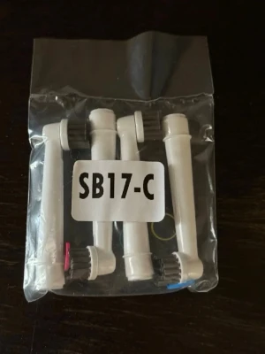 SB17-C borsthuvuden till eltandborste - Fyra vita utbytesborsthuvuden till eltandborste i plast, förpackade i en genomskinlig plastpåse. Borsthuvudena har färgmarkeringar i blått, rött och gult. Passar till eltandborstar med kompatibelt fäste.
