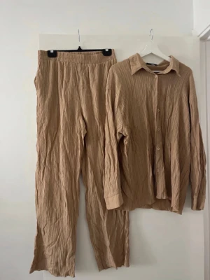 Beiga linnebyxor med resårmidja - Säljer ett par beiga linnebyxor i mjukt, krinklat material. Byxorna har rak passform och resår i midjan för en avslappnad och bekväm stil. Perfekta för dig som gillar en enkel och trendig look.