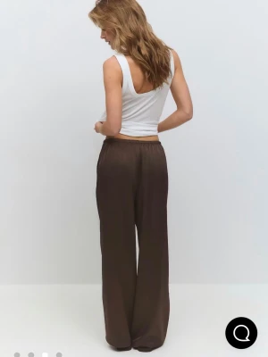 Satin byxor - Säljer ett par bruna satinbyxor från Ginatricot. Materialet är flowy som ger en avslappnad look. Funkar att båda klä upp och ner! Jag är 167cm och dom drar i marken oavsett om jag har dom högmodjade eller lågmidjade! Båda sätten går de att bära dom på och de ser lika bra ut!