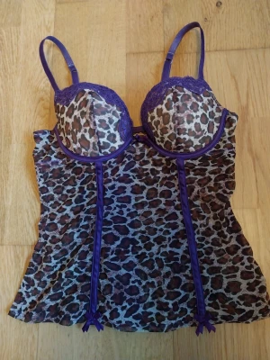 Leopard-mönstrad korsett topp - Jättesnygg lila och leopard-mönstrad korsett topp i mesh som tyvärr inte pasar mig! Köpt secondhand, skulle uppskatta kupan till 75b eller liknande💗🐆
