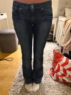 Mörkblå bootcut jeans - Säljer ett par mörkblå bootcut jeans med klassisk femficksdesign och låg midja. Jeansen har snygga kontrastsömmar och en lätt tvättad look. Perfekta för dig som gillar en tidlös och avslappnad stil. Passar mig bra som har 35 cm i midja och 85 cm i innerbenslängd💖
