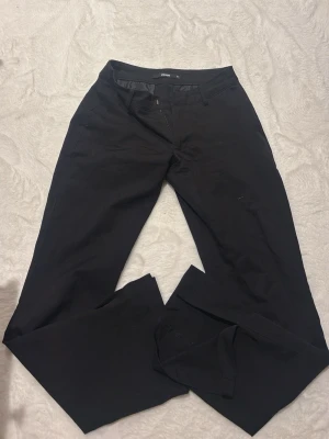 Svarta kostymbyxor från BikBok - Säljer ett par klassiska svarta kostymbyxor från BikBok i storlek 34. Byxorna har raka ben, normal midja och stängs med dragkedja och hake. Perfekta till en stilren look och enkla att matcha med olika toppar. Original pris:600 