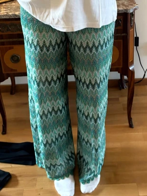 Missoni inspirerade gröna glittriga jyxor - Missoni inspirerade byxor. Sååå söta och trendiga! Långa. Lite stora i midjan på mig som bär storlek s men det är bara att sy själv eller hos skräddaren. Har fickor i sidan, lite extra tyg ( typ shorts inne) så de är inte genomskinliga vid rumpan. Sjukt snygga. Glittrar   Jag är 168. Bra skick inga fel Står storlek s men är nog med m