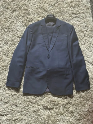 Mörkblå skräddarsydd kostym  -  Tjena säljer en skräddarsydd kostym från Thailändska skräddaren carters fashion i Ao nang. Kostymen är uppsydd till en man på ca 190cm och 88-95 kg. Skickar gärna fler bilder vid begäran.