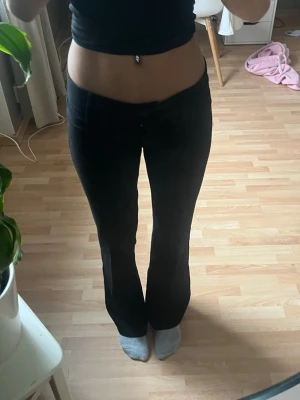 Svarta kostymbyxor - Säljer ett par svarta bootcut byxor med låg midja. Byxorna har en snygg passform som sitter tajt upptill och släpper ut vid benen. Perfekta till en trendig och avslappnad look.