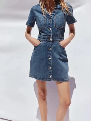 Kort jeansklänning med knappar - Snygg kort jeansklänning med knappar framtill, två bröstfickor och korta ärmar. Klassisk blå denim med markerad midja och fickor i sidorna. Perfekt för en avslappnad och trendig look. Den är från Zara och säljer då den ej passar mig längre endast använd en gång