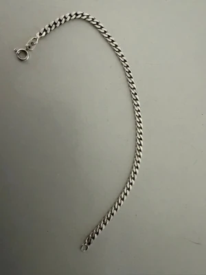 Klassiskt silver kedje armband - Snyggt armband i silver, tätt sammanlänkade länkar och enkel karbinhake. Armbandet har en stilren och tidlös design som passar till många olika stilar. Materialet är silver.
