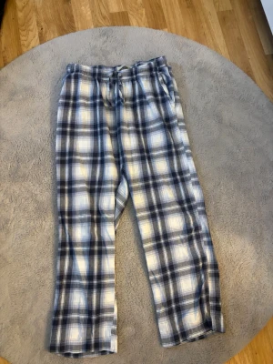 2 par rutiga pyjamasbyxor i bomull - Mysiga pyjamasbyxor med blått, vitt och grått rutmönster. Byxorna har resår i midjan för extra komfort och är tillverkade i mjuk bomull. Perfekta för slappa dagar hemma eller en skön natts sömn. Använda få tal gånger då dom inte är min typ av byxor