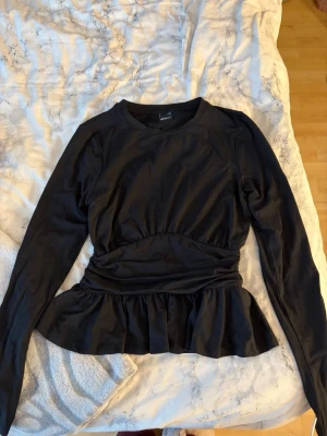 Svart topp gina - Snygg svart långärmad topp med markerad midjedetalj. Köpt på gina, aldrig använd, storlek S 