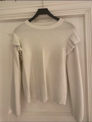 Vit stickad långärmad tröja med volang  - 💓Från vila 🤩Storlek L men passar M oxå (beror på om man vill ha tight eller lös passform) ❗️-VÄLanvänd, nopprig  
