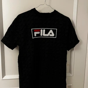 Fila T-shirt  - Säljer en unik Fila T-shirt med ett mönster över tröjan, storlek S. Rejält material och nyskick