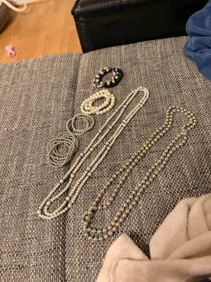 Pärlarmband i olika färger - Flera armband i pärlmodell, både vita, grå och svarta. Armbanden är elastiska och består av små och mellanstora pärlor i plast eller glas. Perfekta för att mixa och matcha till olika outfits. Säljes som ett set.